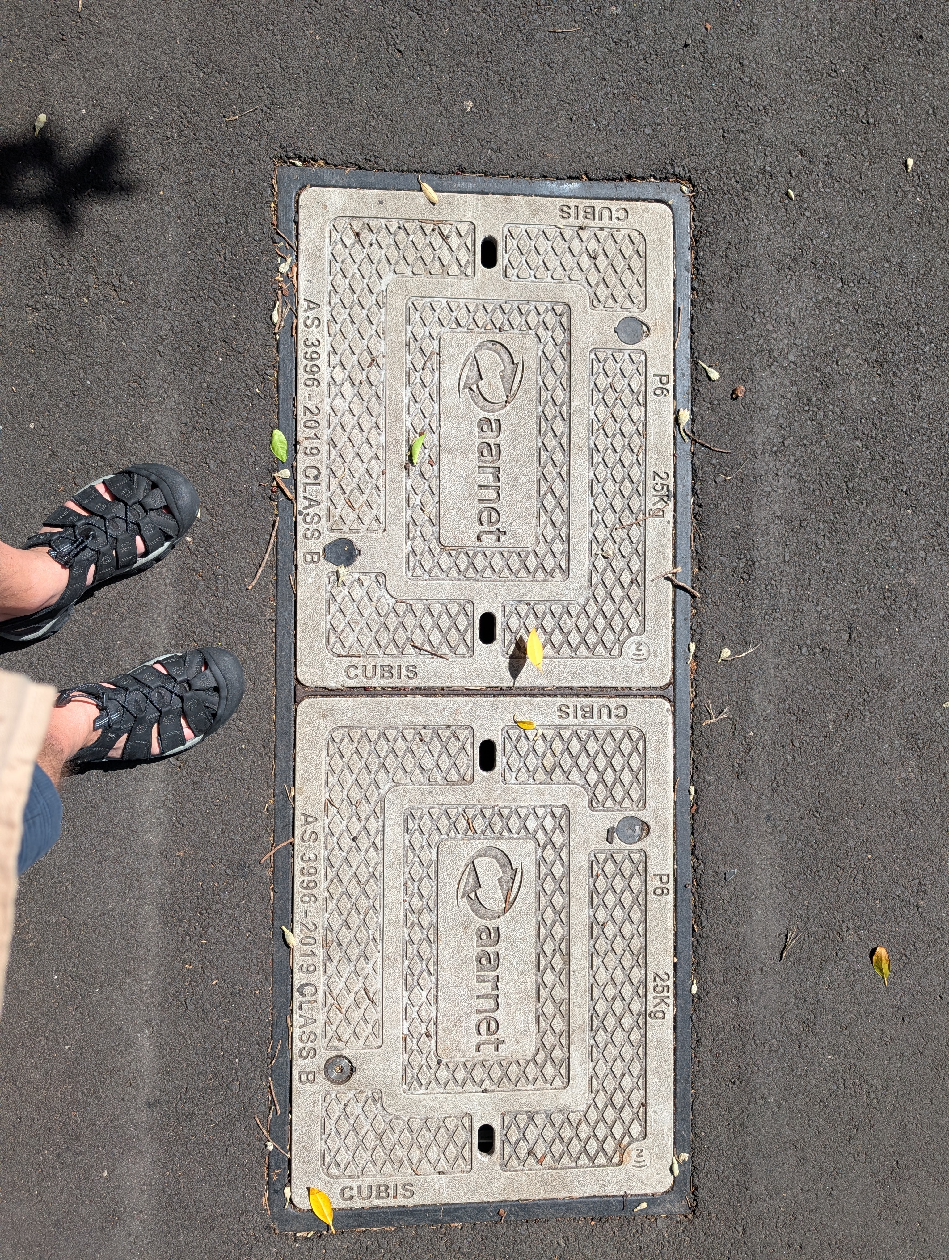 Telecommunications access cover on street with NFC symbol marking